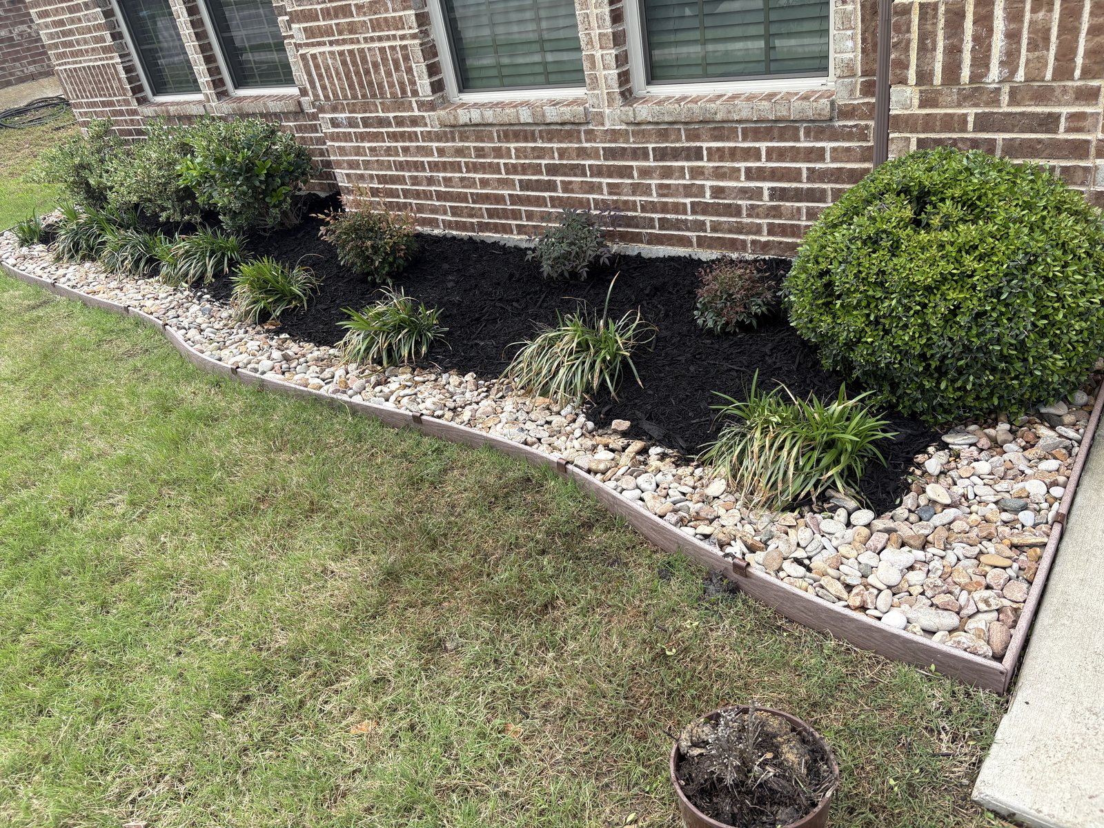Mulched flowerbed with rock border in Denton TX